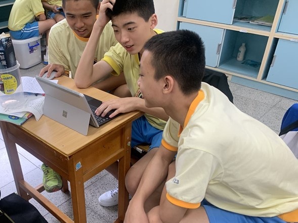 Hai Shan School Sctudents collaborating on a Laptop