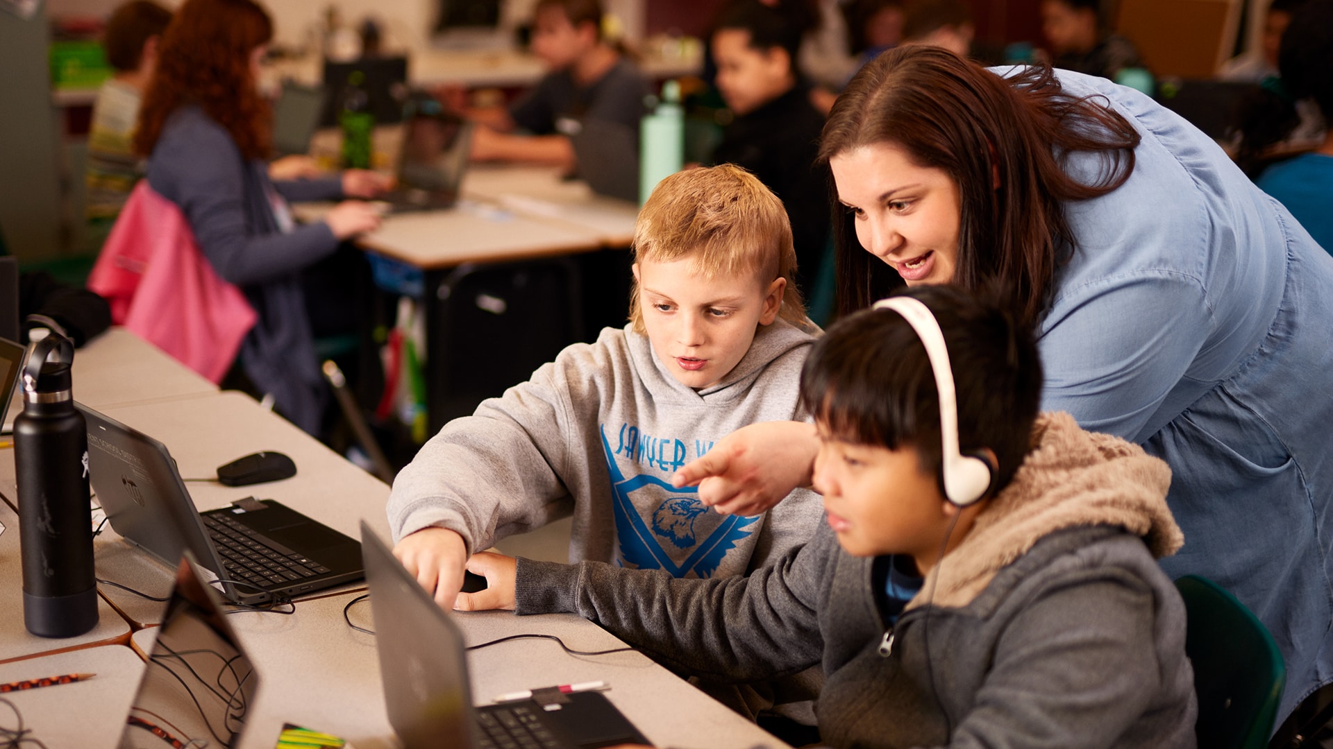 Teacher helping two students