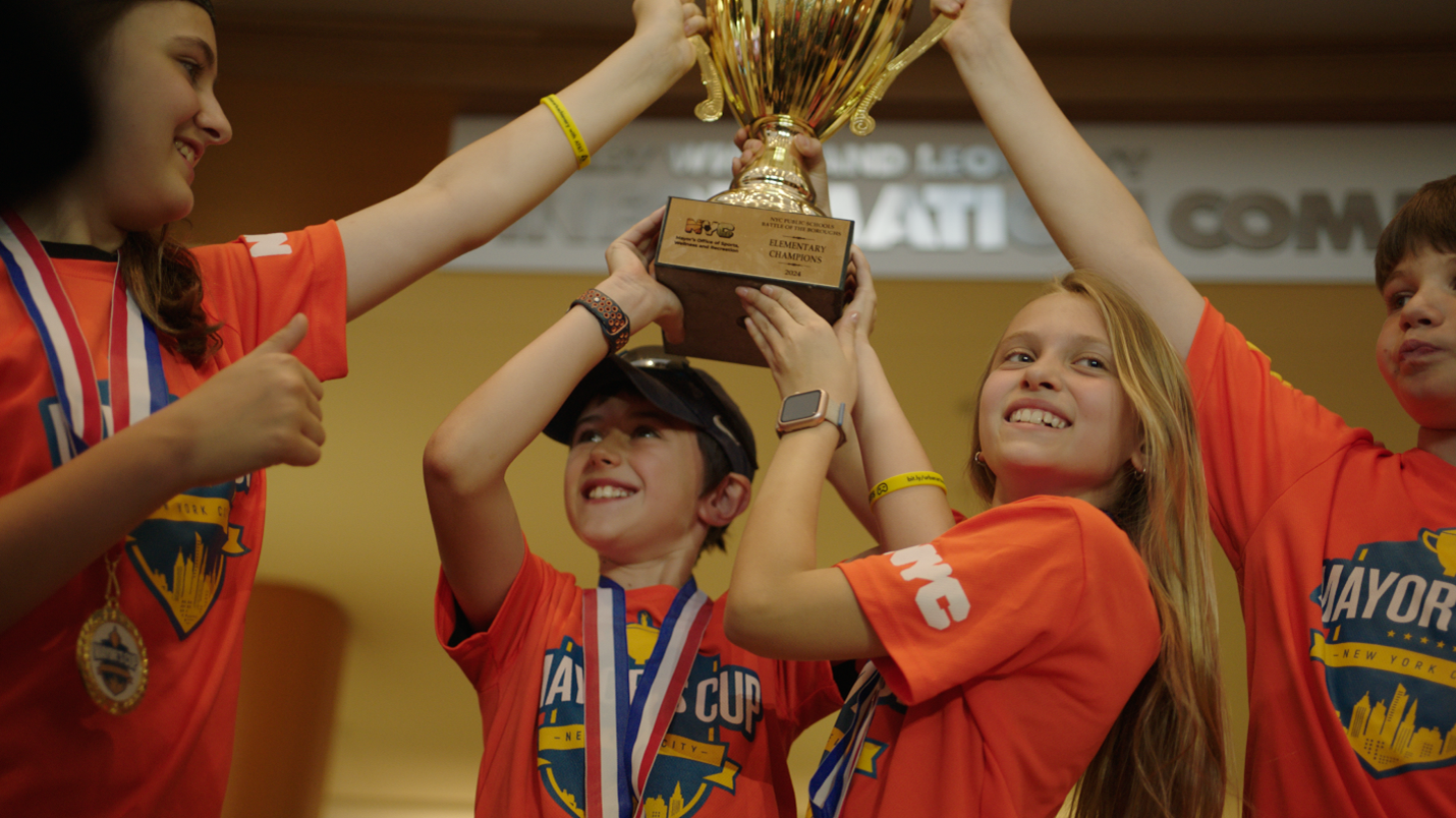 Students hoisting a trophy