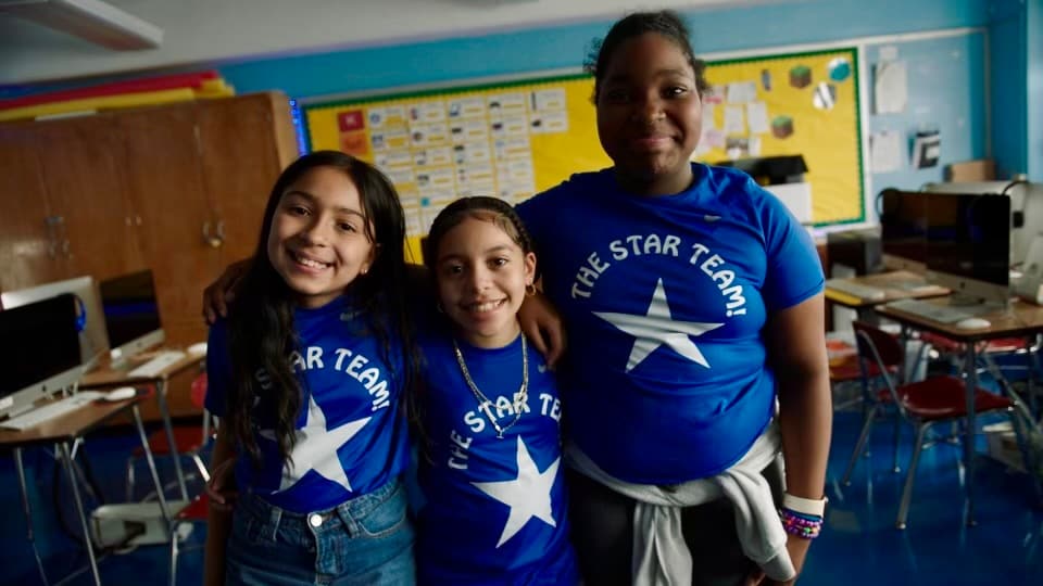 Photo of three students in a classroom