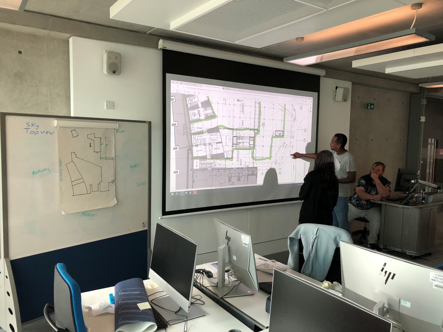 College students collaborating in front of a projector screen